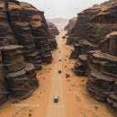 Aerial View of Vehicles Navigating a Desert Canyon