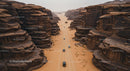 Aerial View of Cars Driving Through Rugged Desert Canyon