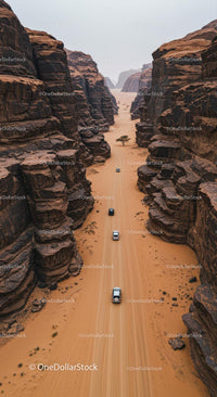 Aerial View of Vehicles Navigating Desert Canyon