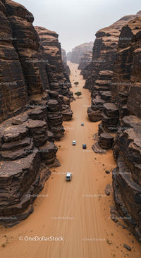 Aerial View of Vehicles Navigating Desert Canyon Path