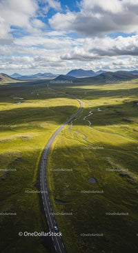 Winding Road Through Expansive Green Plains and Mountains