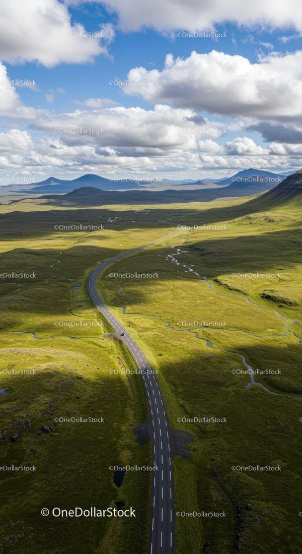Scenic Road Through Vast Green Highlands Under Blue Sky