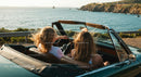Friends on a Coastal Road Trip in Convertible Car