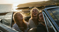 Two Women Driving Vintage Convertible by Ocean