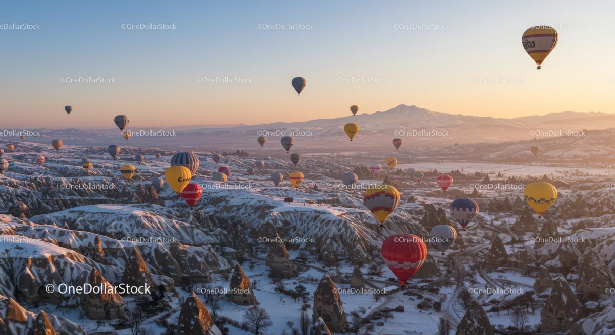 Balony na ogrzane powietrze nad ośnieżoną Kapadocją o wschodzie słońca