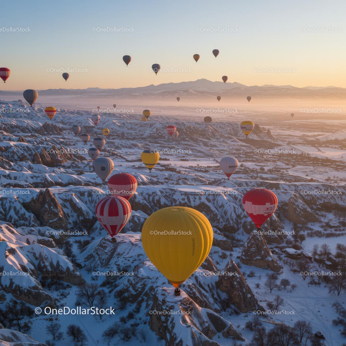 Balony na ogrzane powietrze nad ośnieżoną Kapadocją o wschodzie słońca