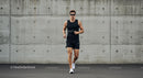 Athletic Man Jogging Against Concrete Wall