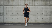 Athletic Man Jogging Against Concrete Wall