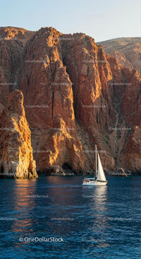 Sailboat Navigating Majestic Red Cliffs at Sunset