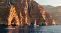 Sailing Boat by Dramatic Rocky Cliffs at Sunset