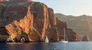 Sailing Boats by Sunlit Red Cliffs, Serene Coastal Escape