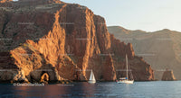 Sailing Boats by Sunlit Red Cliffs, Serene Coastal Escape