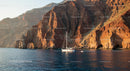 Sailing Along Rugged Rocky Cliffs at Sunset