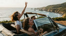 Friends on a Coastal Road Trip in Convertible Car