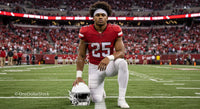 Football Player Kneeling on Field in Red Jersey