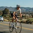 Man Cycling on Scenic Road with Mountain Views