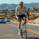 Cyclist on Sunny Mountain Road with Scenic Background
