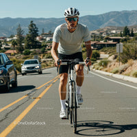 Man Cycling on Scenic Mountain Road on a Sunny Day