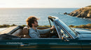 Man Driving Convertible Along Scenic Coastline