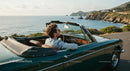 Two Women Driving Vintage Convertible by Ocean