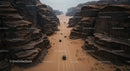 Convoy of Cars Traversing a Desert Canyon Path