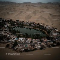 Aerial View of Desert Oasis Surrounded by Sand Dunes