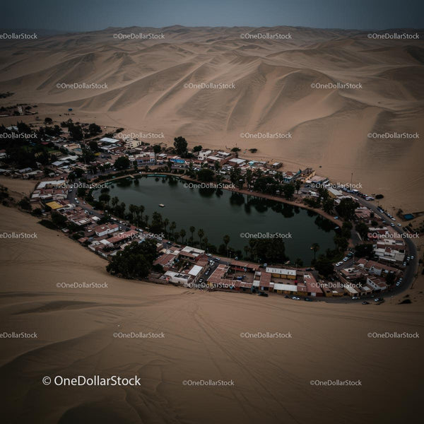 Aerial View of a Desert Oasis Surrounded by Sand Dunes