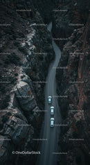Aerial View of Cars Driving Through Rugged Canyon Road