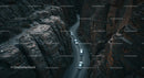 Cars Navigating a Serpentine Road Through Steep Canyon