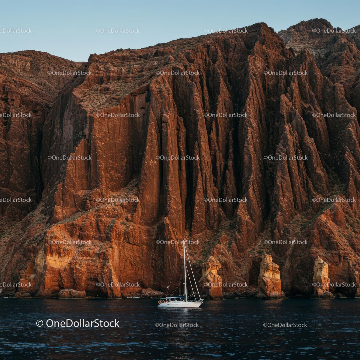 Sailing Boat and Dramatic Cliffs at Sunset