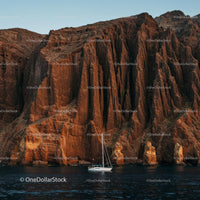 Sailing Boat and Dramatic Cliffs at Sunset