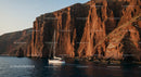 Majestic Cliffs and Yacht in Tranquil Blue Waters