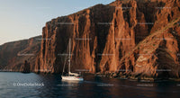 Majestic Cliffs and Yacht in Tranquil Blue Waters