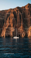 Sailing Yacht Against Majestic Rocky Cliffs at Sunset