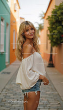 Blonde Woman in Off-Shoulder Top on a Colorful Street