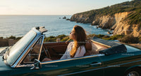 Woman Enjoying a Coastal Drive in Convertible at Sunset