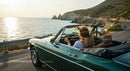 Convertible Car Driving Along Scenic Coastal Road at Sunset