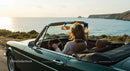 Woman Driving Convertible by Seaside at Sunset