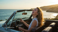 Joyful Woman Driving by the Sea at Sunset