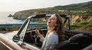Joyful Woman Driving Convertible on Scenic Coastal Road