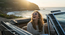 Joyful Woman Enjoying Sunset Drive Along Coastal Road