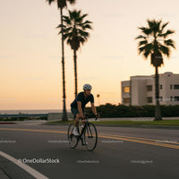 Cyclist Enjoying a Sunset Ride Along a Palm-Lined Road