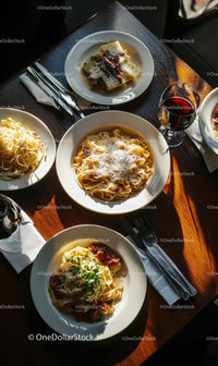 Italian Pasta Dishes with Red Wine on Sunlit Table