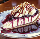 Gourmet Cheesecake Slice with Berry Sauce and Walnuts