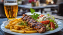 Grilled Meat with Fries and Salad on Outdoor Table