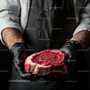 Butcher Holding Fresh Ribeye Steak in Gloved Hands