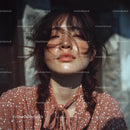 Sunlit Portrait of a Woman with Messy Hair and a Cozy Look