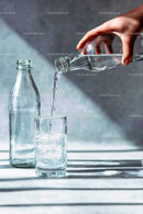 Pouring Water into a Glass with Sunlit Reflections
