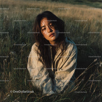 Peaceful Woman in a Sunlit Wheat Field at Dusk