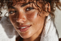 Close-Up of Woman with Freckles and Curly Hair in Warm Light